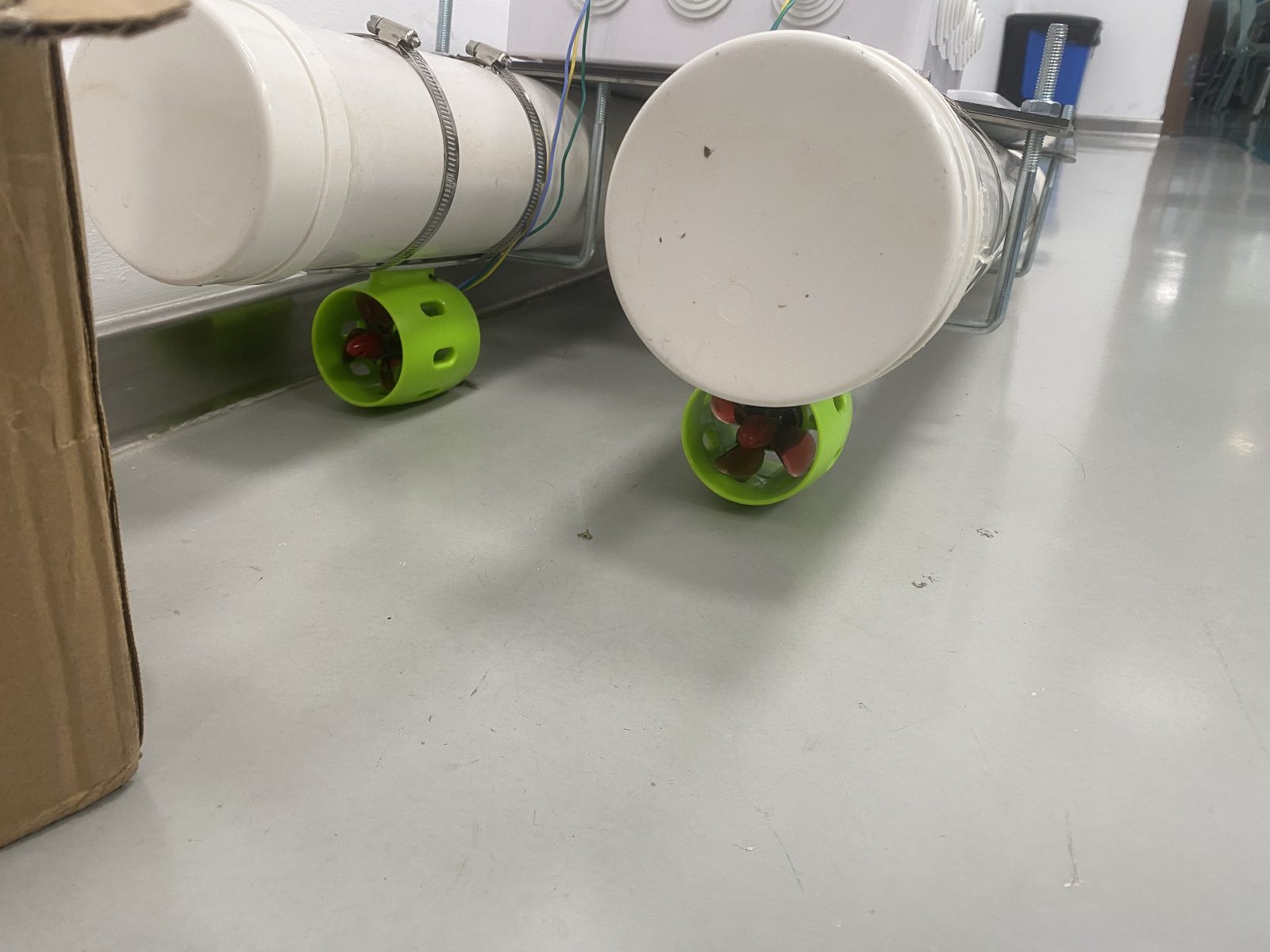 Two green ducted thrusters clamped beneath the pontoon sterns